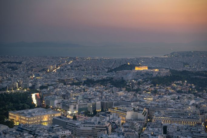 Panorama von Athen bei Sonnenuntergang, Akropolis beleuchtet im Hintergrund.
