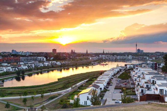 Sonnenuntergang über Dortmund mit dem Phoenixsee und modernen Wohngebäuden.